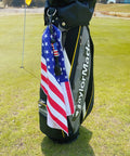 Magnetic Golf Club Cleaning Kit With American Flag Towels clipped to golf bag, displayed on course.
