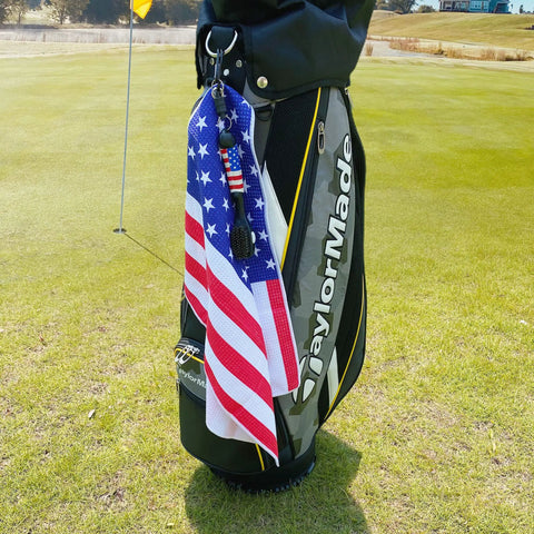 Magnetic Golf Club Cleaning Kit With American Flag Towels clipped to golf bag, displayed on course.