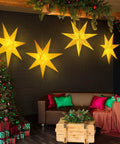 Two Pack 24 Inch Paper Star Lanterns With 50 LED Fairy String Lights Eight Modes Seven Pointed Hollow Star Hanging Decor For Indoor Outdoor Rooms Weddings Christmas Parties Lit Vibe illuminating a cozy living room.