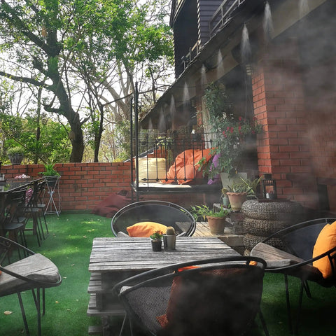 Outdoor patio with mist from the Outdoor Misting Cooling System Kit With Pump And Filter 49.2 Ft Misting Line With 20 Brass Nozzles