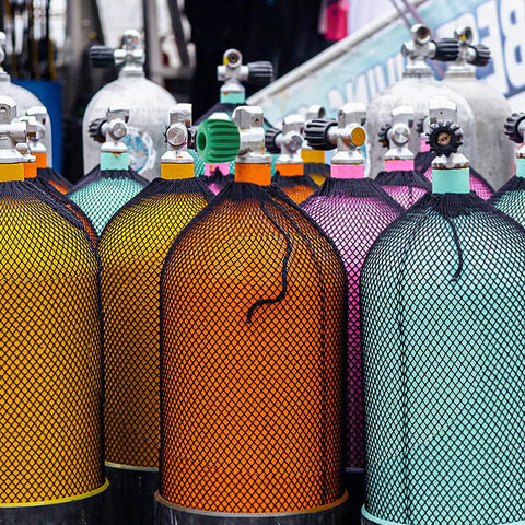 Colorful scuba tanks with black nets featuring Diving Tank Valve Handle Stainless Steel Regulator Control Knob For Scuba Gear.