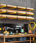 Heavy Duty Folding Lumber Storage Rack 3 Level Wall Mounted Metal Organizer in yellow holds wood above a workshop bench.