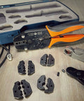Pro Grade All In One RF Coax Tool Kit with quick-change crimper, cutter, stripper, and five interchangeable die sets displayed on table.