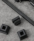 96 Pack Iron Baluster Shoes With Screws For Half Inch Square Balusters Satin Black No-Fuss Install For Twist Knuckle Basket Staircase Railings Heavy Duty Metal Spindle Support showing satin black square baluster shoes on grey surface.