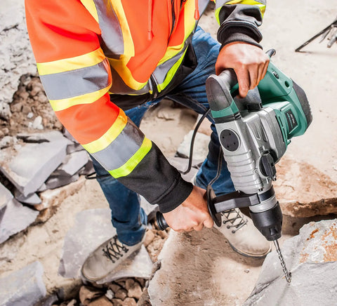 Worker using SDS Plus Rotary Hammer Drill Kit with 11 Pc Accessories on masonry surface, showcasing 12 Amp 1500W motor and 3 modes.