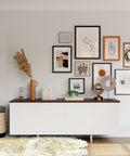 Living room gallery wall with various frames hung using 180 Pairs Large Picture Hanging Strips Heavy Duty No Tools Needed Removable Hook And Loop Tape 360 Strips Total Hang Frames Easy No Nails Damage Free Water Resistant Adhesive Strips For Frame Hanging On Walls, above a white cabinet.