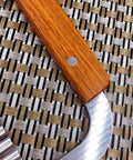 Close-up of Guardians Crinkle Chopper with wooden handle and curved stainless steel blade