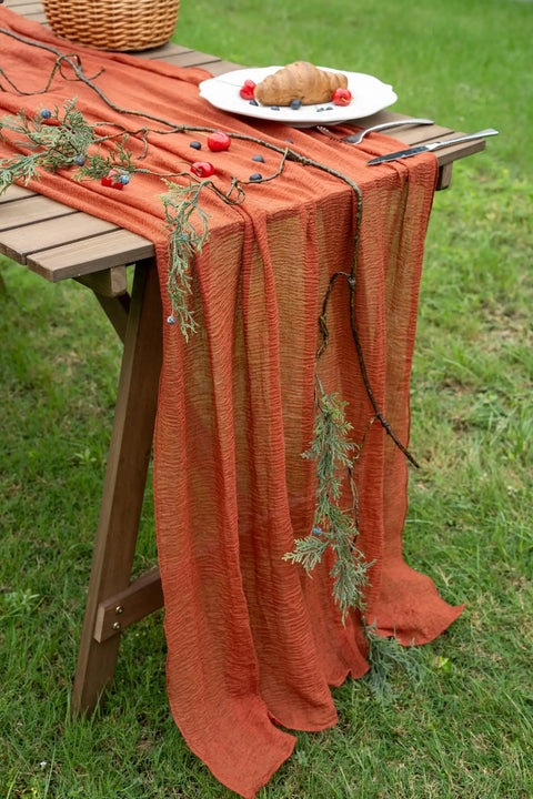Rustic Fall Thanksgiving Table Runner Terracotta Cheesecloth Weave 120 Inches Long Hand Dyed Soft Cotton Gauze on a wooden table with greenery.