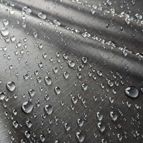 Close-up of water beading on fabric treated with Revivex DWR Spray For Waterproof Jackets And Rain Gear Keeps Your Gear Dry And Gore-Tex Breathable With Water Beading Again Restore Waterproofing For Tents Camping Gear And Winter Wear For Real World Adventures