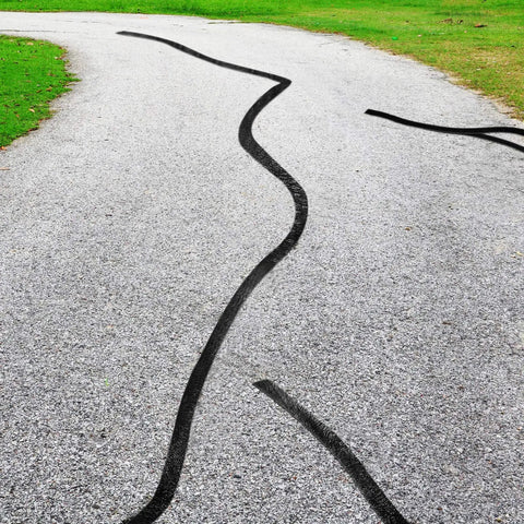 Driveway with 2 Inch Self Adhesive Asphalt Crack Filler Tape For Driveways And Parking Lots applied to repair cracks.