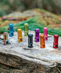 Colorful Oil Slick Alloy Valve Cap With Built In Valve Core Remover No Tools Needed For Presta Valves on a rock