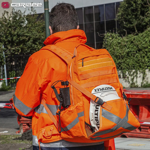 Worker wearing Hi Vis Orange Safety Backpack With Reflective Panels, Adjustable Hard Hat Holder, and utility pockets on site