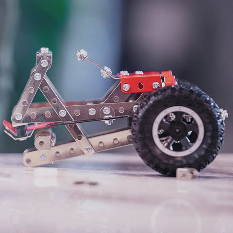 Close-up of a vehicle model from Beast Mode Erector Set Metal Model Kit For Adults Teens And Advanced Kids Build Cars Planes And Excavators With Realistic Pieces STEM Educational Toy And Engineering Challenge, showing metal parts and wheel assembly.