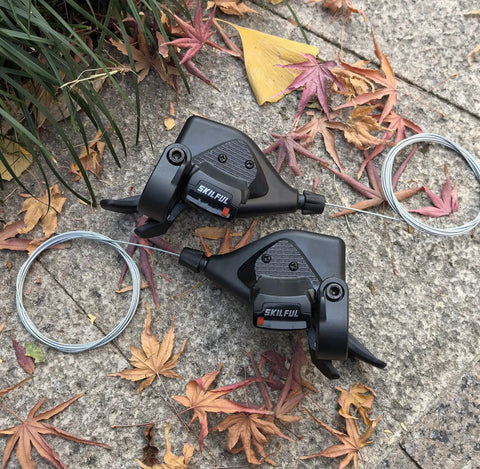 Left 3 Speed Thumb Shifter And Right 7 Speed Gear Shifter With Gear Indicator For 21 Speed Bicycles on stone path with leaves
