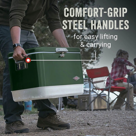 Person lifting Vintage 54 Quart Steel Belted Cooler With Have A Seat Lid Ice Lasts Up To Four Days Fits 85 Cans Drain Rust Resistant Hardware Retro Design For Backyard Barbecues Camping And Weekend Get Togethers by comfort-grip steel handles at a campsite.
