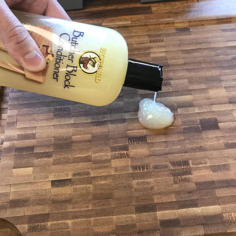 Butcher Block Oil And Conditioner Cutting Boards Food Grade Rehydrates Wood 12 Oz being poured onto a wooden cutting board
