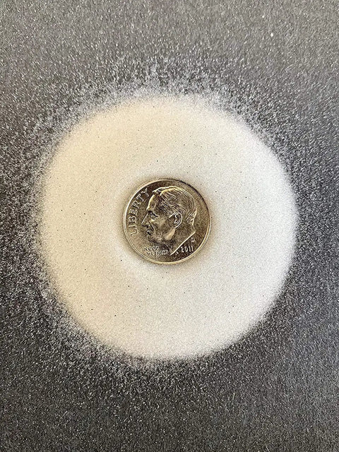 Glass Beads Sandblasting Media Number Six Coarse 50-70 Grit 10 Lbs alongside a dime on dark surface