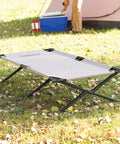 Trailhead II Large Folding Camping Cot with steel frame on grass near a tent, supports up to 300 lbs, stands 6 ft 2 in tall, portable