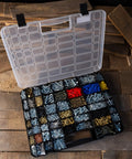 Open portable storage case with secure locks and 55 small bin compartments for hardware, screws, bolts, and more, on wooden surface.