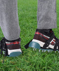 Person wearing Lawn Aerator Shoes For Grass And Garden Care With Spiked Prongs And Easy Buckle Straps on grass