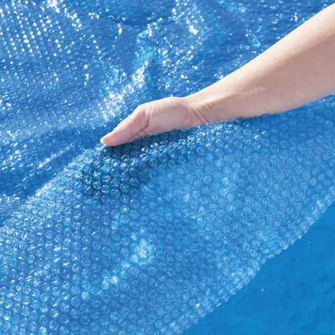 Close-up of hand holding Hella Effective 10 Foot Solar Pool Cover made of blue mesh, showing its bubble design for trapping heat.