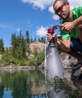MiniWorks EX Backcountry Water Purifier System With Microfilter Pump in use by lake for hiking and emergency prep