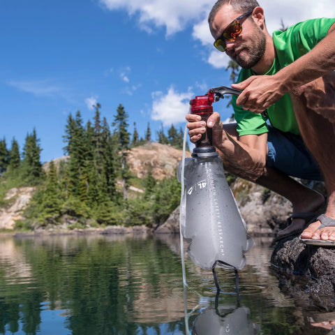 MiniWorks EX Backcountry Water Purifier System With Microfilter Pump in use by lake for hiking and emergency prep