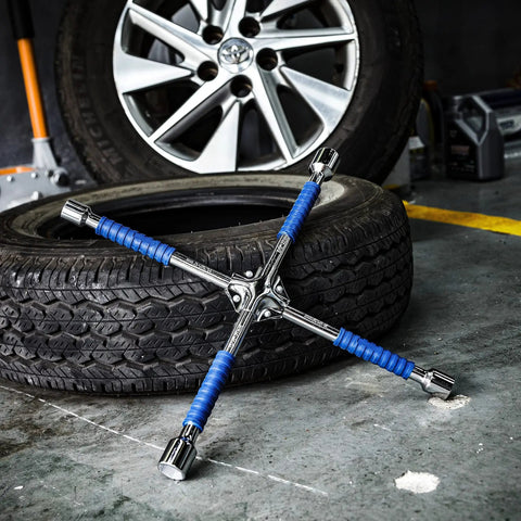 Beefy 16 Inch Universal Lug Wrench Four Way Tire Iron With Non Slip Handle For Cars Light Trucks SUVs Vans And RVs Includes 17mm 19mm 21mm And 22mm Lug Sizes Heavy Duty Blue Finish Built To Last on garage floor with tire in background