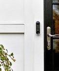Essential Wired Video Doorbell With HD Video, 180 Degree View, Night Vision, Two Way Audio next to a front door