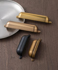 Antique Brass Zinc Alloy Cup Drawer Pulls Set of 6 For Kitchen Cabinets and Drawers on wooden surface.