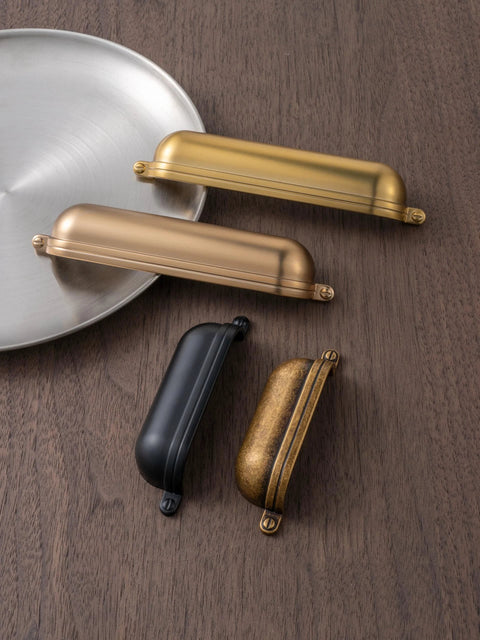 Antique Brass Zinc Alloy Cup Drawer Pulls Set of 6 For Kitchen Cabinets and Drawers on wooden surface.