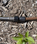 Drip irrigation tubing-to-hose adapter, 1/2 in, black plastic quick-connect fitting on mulch