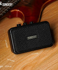 Ultra Portable 5W Mini Guitar Amp For Electric Guitars With Two Speakers And Rechargeable Battery on a wooden surface.