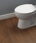 Sanborne Elongated Slow Close Toilet Seat With No Slip Bumpers installed on white toilet in bathroom with wood floor