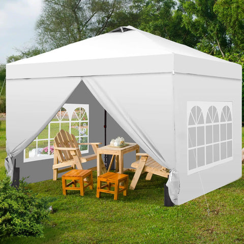 10x10 Pop Up Canopy Tent With Four Sidewalls One Push Setup for Quick No Tool Outdoor Shade Silver Coated Canopy Includes Sandbags Ideal for Parties Events Camping and Beach White, set up on grass with chairs and a table inside, white color.