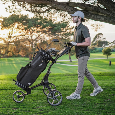 Golfer using 3 Wheel Foldable Golf Push Cart Ultra Lightweight Go-To On The Green Sidekick with height adjustable handle