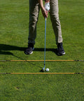 Golfer using Heritage Wood Golf Alignment Sticks With Cover Vintage Hickory Style Practice Aids for alignment on grass.