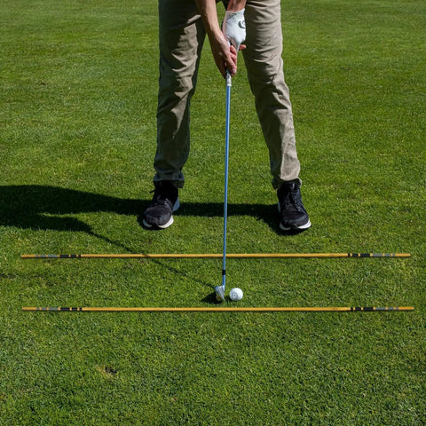 Golfer using Heritage Wood Golf Alignment Sticks With Cover Vintage Hickory Style Practice Aids for alignment on grass.