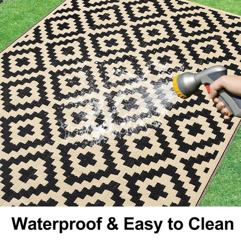 Waterproof Outdoor Rug 5x8 Ft Reversible Plastic Straw Pattern Patio Camping Mat with black and beige design being cleaned