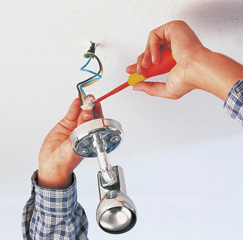Hands using Insulated SoftFinish 7 Piece Screwdriver Set Pro Grade VDE Tested Up To 1000V on ceiling light installation.