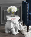 White Elephant Ceramic Garden Stool 14.25 Inch Glazed Elephant Seat with books and flowers in a living room setting