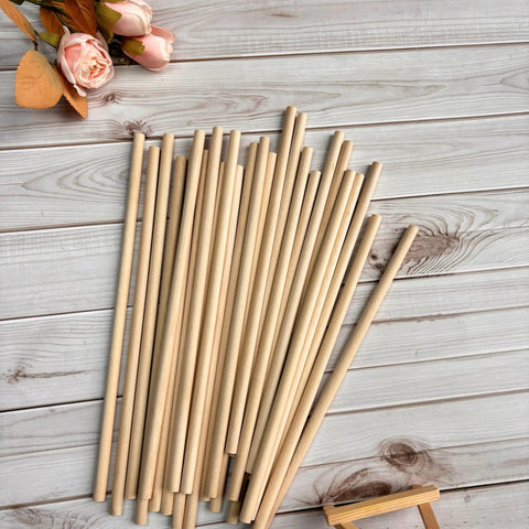 Hassle Free 25 Pack Wood Dowel Rods 3/8 Inch By 15 Inch Smooth Unfinished Craft Sticks arranged on wood surface.