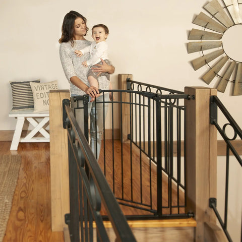 Multi-Use Tall Walk-Thru Baby Gate In Black Metal, Pressure Mount Or Hardware Mount Options, shown at the top of the stairs.