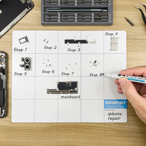 Hand using dry-erase marker on Magnetic Project Mat And Screw Organizer Pad For Electronics Repair with phone parts.