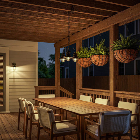 Broadcast 3 Light Outdoor Chandelier In Oil Rubbed Bronze With Copper Highlight Finish illuminating a rustic patio with wooden furniture at night.