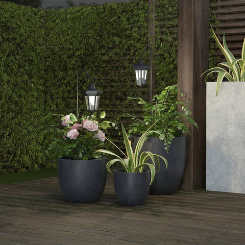 Set Of 2 Solar Lanterns For Outdoors, Waterproof Hanging LED Lights With Shepherd Hook Mounts on patio with potted plants at night