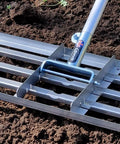 38 Inch Wide Leveling Lawn Rake With Stainless Steel Head And 72 Inch Aluminum Handle in use on soil, close-up of metal head and shaft