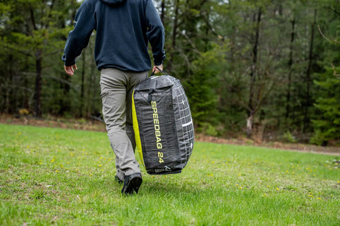 Person carrying Beast 24 Inch Dual Sided Archery Target For 475 FPS Compound Bows And Crossbows in wooded area