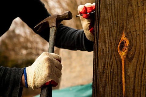 Person using a hammer with Economical String Knit Latex Dipped Palm Gloves With Nitrile Coated Fingers For General Purpose Work