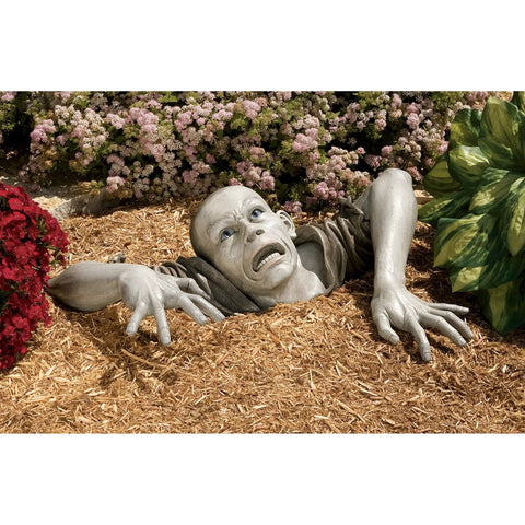 Zombie Of Montclaire Moors Indoor Outdoor Garden Statue Halloween Decor in mulch with flowers, 31 inches wide, resin material